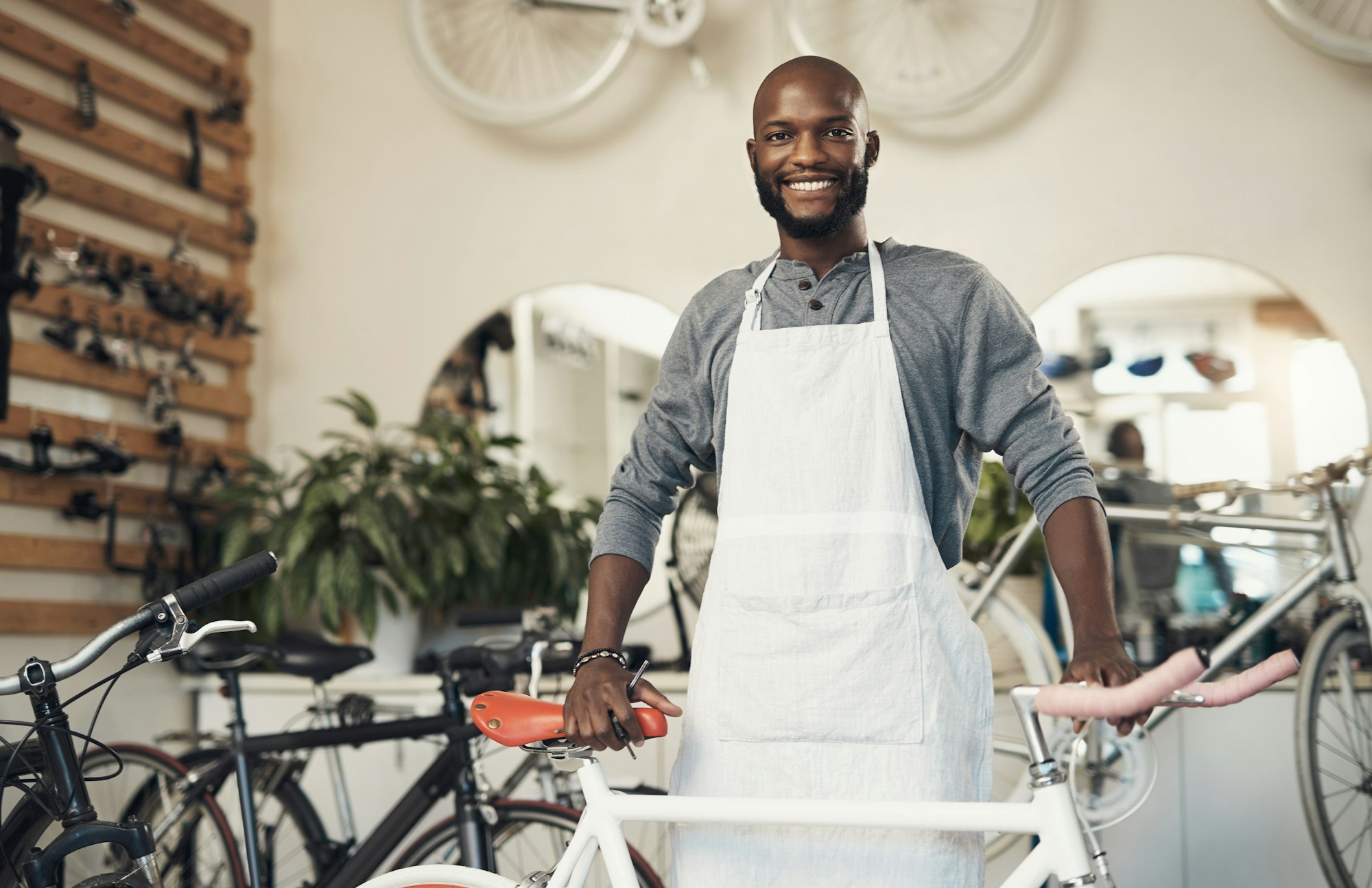Proud business owner standing in his bicycle repair shop